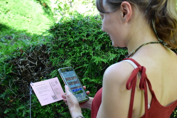 Junge Frau scannt QR-Code